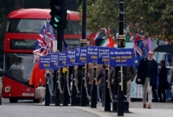 FILE - Brexit opponents display their posters in front of Parliament in London, Oct. 23, 2019.