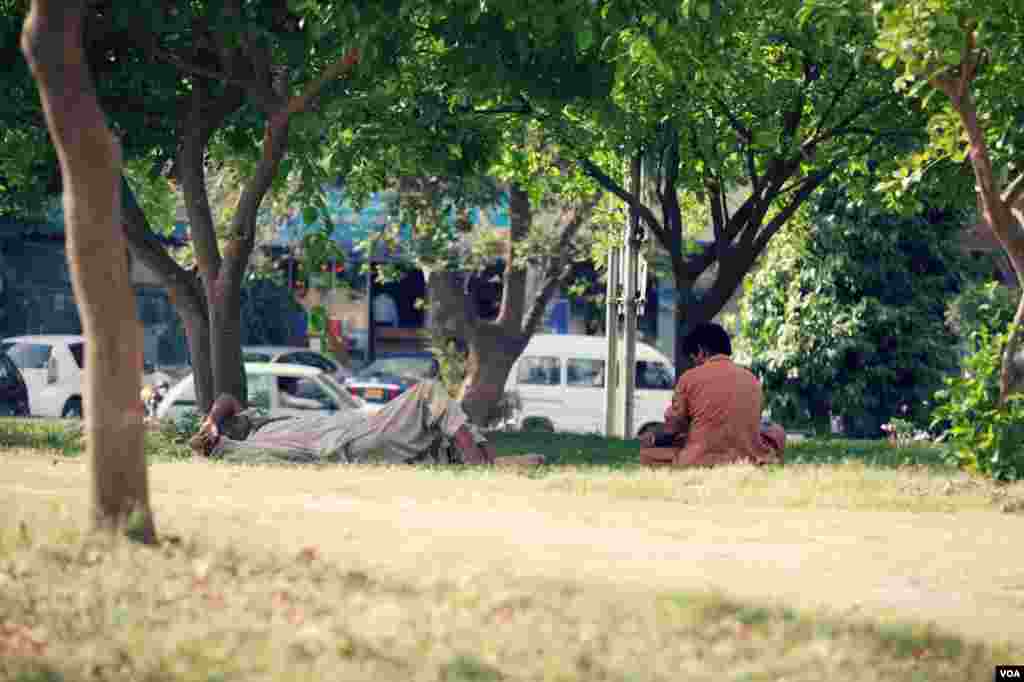 گرین بلیٹ یعنی سبز پٹی پر سائے میں بیٹھے مزدور