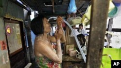 A Thai woman takes a shower in a narrow alley in a flooded neighborhood in Bangkok, Thailand, November 8, 2011.