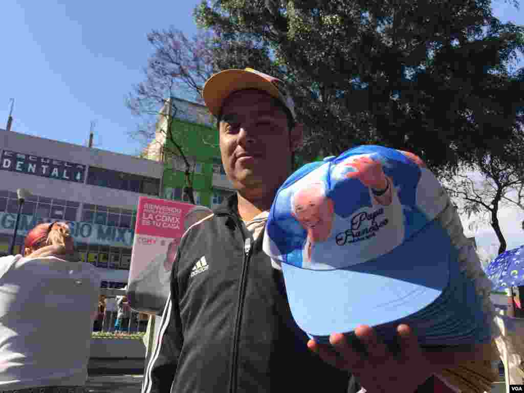 Topi kenang-kenangan dijual di pinggir jalan yang akan dilalui oleh Paus, Mexico City, 13 Februari 2016. (C. Mendoza/VOA)