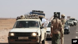 A man waves a white flag from a car loaded with his family and their belongings at a rebel checkpoint 99 miles (160 kilometers) from Sirte, Libya, August 28, 2011