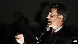 Republican presidential candidate, former Pennsylvania Senator Rick Santorum, is lit by utility lights as he speaks at an evening outdoor rally in Tacoma, Washington, February 13, 2012.