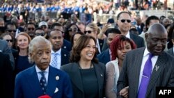 FILE —US Vice President Kamala Harris (2nd L), Civil rights attorney Ben Crump (R) and the Reverend Al Sharpton (L) join a march across the Edmund Pettus Bridge during a commemoration of the 59th anniversary of Bloody Sunday in Selma, Alabama, March 3, 2024.