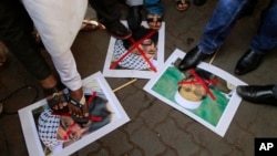 Indian protesters stamp placards with pictures of Pakistani Mujahiddeen leader Masood Azhar, left, as they condemn the attack on the Pathankot air force base in Mumbai, India, Jan.4, 2016. 