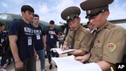 South Korean basketball players their identifications checked by North Korean officials upon their arrival at the Pyongyang Airport in Pyongyang, North Korea, July 3, 2018. 