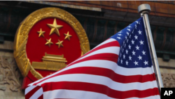 中国国徽与美国国旗。