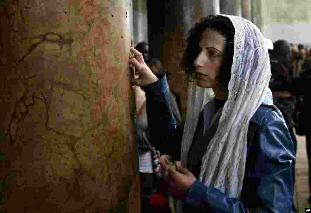 A Catholic pilgrim touches a column inside the Church of the Nativity in the West Bank town of Bethlehem,December 24, 2012. Thousands of Christian worshipers and tourists arrived in Bethlehem to mark Christmas at the site many believe Jesus Christ was born. 