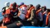 Un membre de l'équipage du Sea-Watch 3 vient en aide à un groupe de 47 migrants lors du transfert d'un bateau pneumatique secouru lors d'une opération de sauvetage vers les côtes libyennes, 19 janvier 2019.