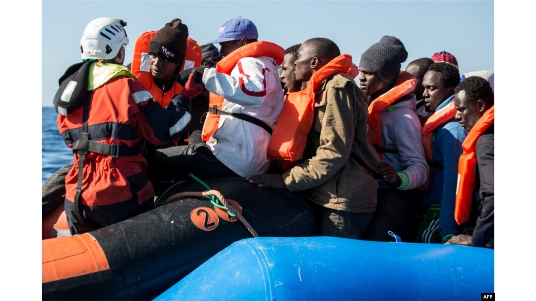 FILE - A group of migrants is helped by a Sea-Watch 3 crew member, left, during their transfer from a rescued inflatable boat onto a Sea-Watch 3 RHIB (Rigid Hull Inflatable Boat) during a rescue operation by the Sea-Watch 3 off Libya's coasts, Jan. 19, 2019.