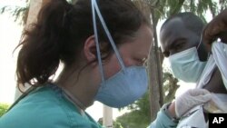 Dr. Megan Coffee examines a patient named Stanley who has tuberculosis at Port-au-Prince Hospital