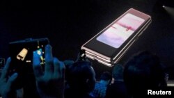 FILE - The Samsung Galaxy Fold phone is shown on a screen at Samsung Electronics Co. Ltd.’s Unpacked event in San Francisco, Feb. 20, 2019. Samsung says it will look into some reports of flickering or cracking screens.