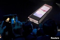 FILE - The Samsung Galaxy Fold phone is shown on a screen at Samsung Electronics Co. Ltd.’s Unpacked event in San Francisco, Feb. 20, 2019.