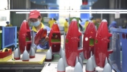 In this May 27, 2020, photo released by Xinhua News Agency, a worker makes plastic toys at a factory in Zhangjiajie, central China's Hunan Province.