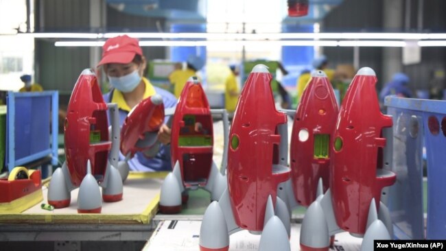 In this May 27, 2020, photo released by Xinhua News Agency, a worker makes plastic toys at a factory in Zhangjiajie, central China's Hunan Province.
