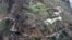 This photo made available by the U.S. Coast Guard, shows homes near a washed out road in Utuado, Puerto Rico, Oct. 3, 2017. 
