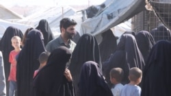 Foreign women in al-Hol camp crowd around VOA journalists, complaining their sons were taken to a deradicalization center on Oct. 20, 2021 in al-Hol, Syria. (Ali Zeyno/VOA)