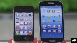 Samsung Electronics' Galaxy S III, right, and Apple's iPhone 4S are displayed at a mobile phone shop in Seoul, South Korea, August 24, 2012.