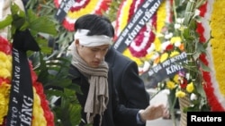 FILE - Vietnamese dissident Nguyen Tien Trung stands between wreaths during a funeral for Hoang Minh Chinh in Ho Chi Minh City, February 16, 2008.