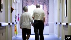 In this Nov. 6, 2015 file photo, an elderly couple walks down a hall in Easton, Pa. Research released on Friday, Nov. 1, 2019 suggests many American adults inaccurately estimate their chances for developing dementia and do useless things to prevent it. 