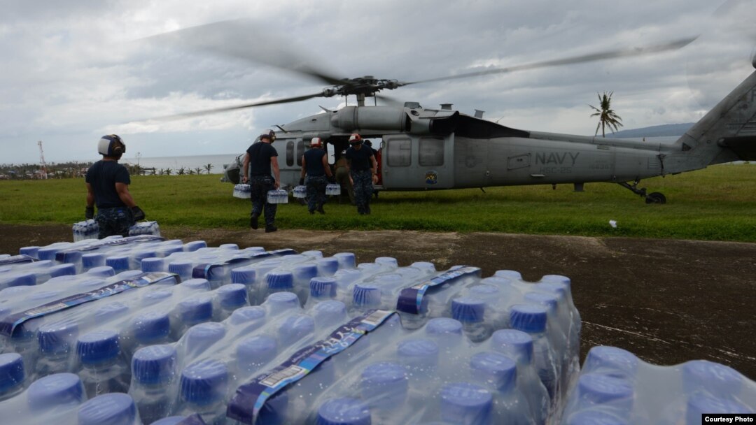 Para petugas bantuan dari tentara angkatan laut Amerika memasukkan bantuan darurat ke helikopter dari kota Ormoc, Filipina untuk para penyintas Topan Haiyan (17/11).
