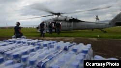 Para petugas bantuan dari tentara angkatan laut Amerika memasukkan bantuan darurat ke helikopter dari kota Ormoc, Filipina untuk para penyintas Topan Haiyan (17/11).