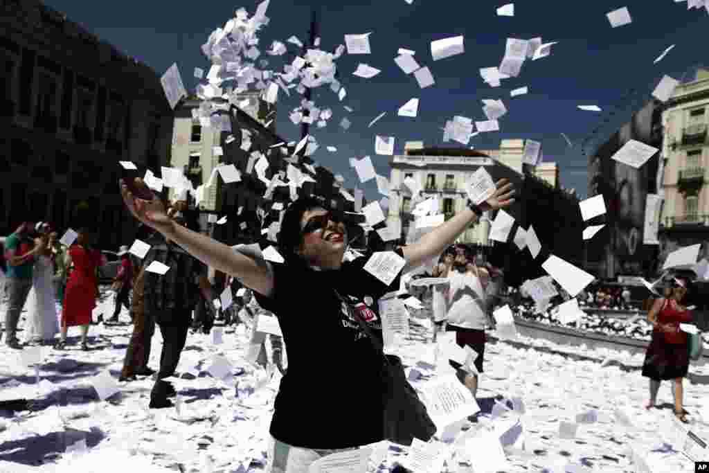 A protester throws leaflets with a question reading &quot;Do you want a public and universal healthcare system? yes or not&quot; during a demonstration against government-imposed austerity measures and labor reforms in the public healthcare sector in Madrid, Spain.