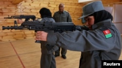 Afghan policewomen aim their guns during shooting exercises at the Afghan National Police Academy shooting range, in Kabul, December 9, 2012.