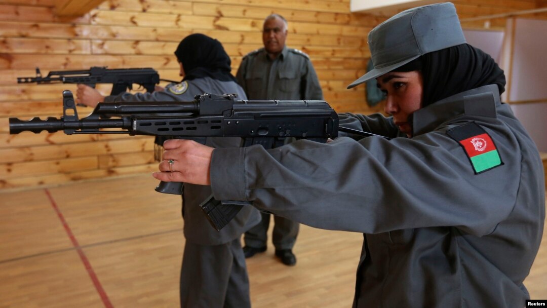 Afghan policewomen aim their guns during shooting exercises at the Afghan National Police Academy shooting range, in Kabul, December 9, 2012.