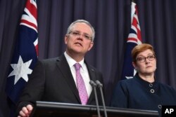 Australian Prime Minister Scott Morrison, left, speaks to the media alongside Foreign Minister Marise Payne during a press conference at the Parliament House in Canberra, Oct. 16, 2018.