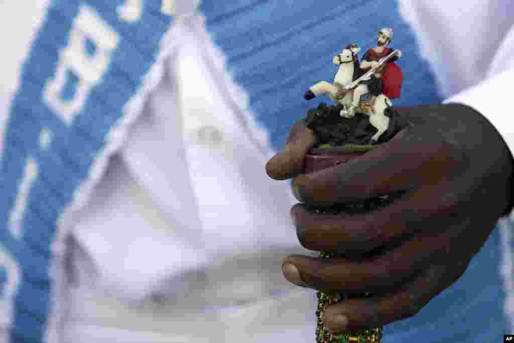 A man holds a walking cane decorated with a statue of St. George during an annual Afro-Christian dance tradition called Congada, in Catalao, Goias state, Brazil, Oct. 9, 2016. St. George is one of the most important and popular saints in Brazilian, and is