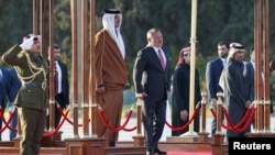 Jordan's King Abdullah II and Qatar's Emir Sheikh Tamim bin Hamad al-Thani review Bedouin honour guards at the Queen Alia International Airport in Amman, Jordan, Feb. 23, 2020. 