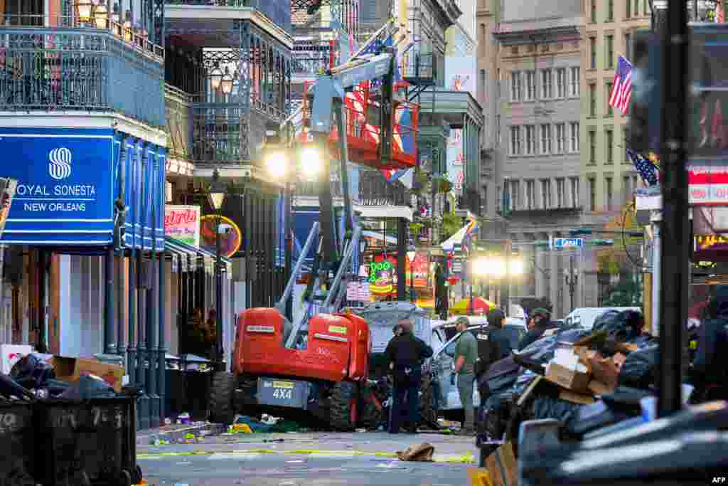 Police investigators surround a white truck that has been crashed into a work lift in the French Quarter of New Orleans, Louisiana.&nbsp;At least 10 people were killed and 30 injured when a vehicle plowed overnight into a New year&#39;s crowd in the heart of the thriving New Orleans tourist district, authorities said.