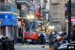 Penyidik polisi mengelilingi truk putih yang menabrak lift kerja di French Quarter, New Orleans, Louisiana, 1 Januari 2025. (Foto: AFP)