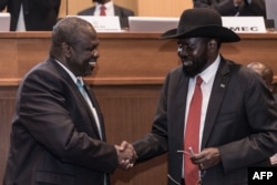 South Sudan's President Salva Kiir, right, and his former deputy turned rebel leader Riek Machar shake hands as they make a last peace deal at the 33rd Extraordinary Summit of Intergovernmental Authority on Development (IGAD) in Addis Ababa on Sept.12, 2018.
