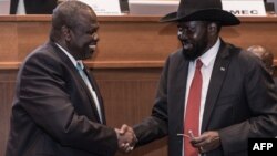 South Sudan's President Salva Kiir, right, and his former deputy turned rebel leader Riek Machar shake hands as they make a last peace deal at the 33rd Extraordinary Summit of Intergovernmental Authority on Development in Addis Ababa on Sept.12, 2018.