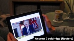 United Kingdom, Teacher Wendy Couldridge watches on a device as Britain's Prime Minister Boris Johnson
