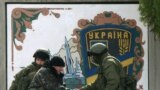 Ukrainian serviceman (2nd L) shakes hand with an armed man, believed to be Russian serviceman, at the Ukrainian military base in the village of Perevalnoye near the Crimean city of Simferopol. Crimea&#39;s pro-Russian prime minister will give people living there the choice of taking Russian or Ukrainian passports if the Ukrainian territory becomes part of Russia in a March 16 referendum.