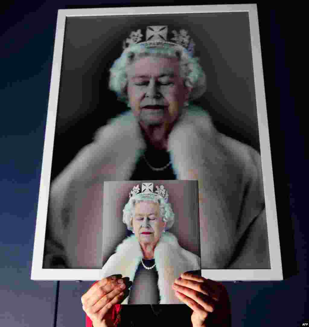 June 23: Gallery assistant Clare McCormack stands in front of a portrait of Britain's Queen Elizabeth titled 'Lightness of Being' by Chris Levine during the exhibition of "The Queen: Art and Image", in the Scottish National Gallery in Edinburgh. REUTERS/D