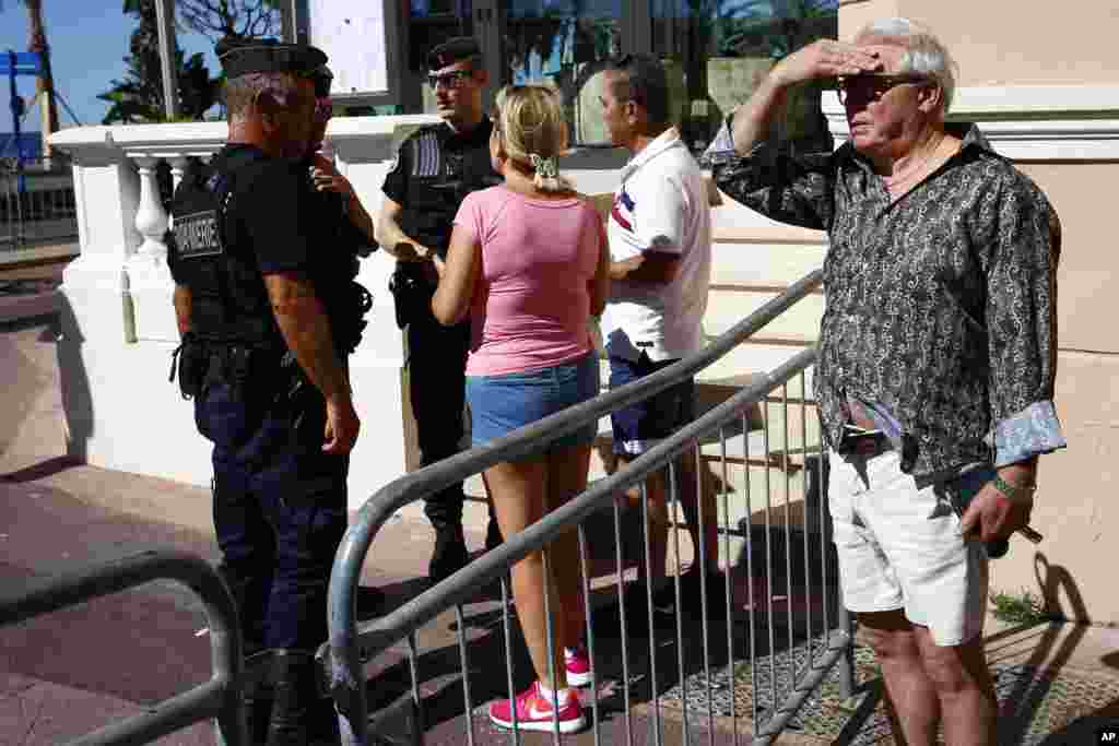 French gendarmes prevent people to enter the scene where a truck mowed through revelers in Nice, southern France, Friday, July 15, 2016.