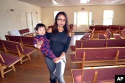 FILE - Ingrid Encalada Latorre walks with her year-old son, Anibal, where she is taking sanctuary at a Denver Quaker center, the Mountain View Friends Meeting, a small, two-story brick structure just blocks from the University of Denver, in Denver.
