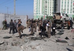 Afghan security personnel investigate at the site of a bomb attack in Kabul, Dec. 15, 2020. A bombing and a shooting attack in the capital killed several people, including Kabul's deputy governor.