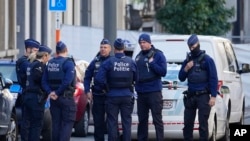 FILE — Belgian Police patrol behind a cordoned off area close to where a suspected Tunisian extremist has been shot dead hours after manhunt looking for him, Oct. 17, 2023. 