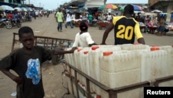 FILE - A boy sells jerrycans at a market area in the Liberian capital of Monrovia.