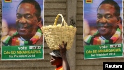 FILE - A street vendor carries fruit outside an election rally of President Emmerson Mnangagwa's ruling ZANU-PF party in Mutare, Zimbabwe, May 19, 2018. 