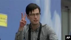 Australian student Alek Sigley gestures as he arrives at the airport in Beijing, July 4, 2019. The Australian student who vanished in North Korea more than a week ago arrived in Beijing on Thursday morning.