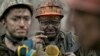 Ukrainian coal miners wait for a bus after exiting the underground of the Zasyadko mine in Donetsk, Ukraine, March 4, 2015.