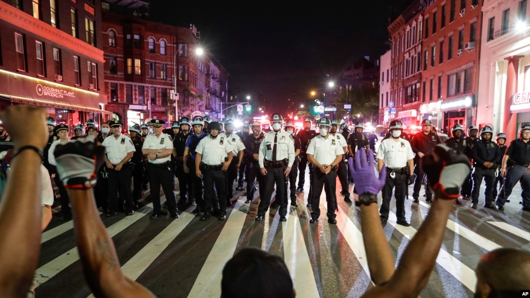 Protesters take a knee on Flatbush Avenue in front of New York City police officers during a solidarity rally for George Floyd, Thursday, June 4, 2020, in the Brooklyn borough of New York. Floyd died after being restrained by Minneapolis police…