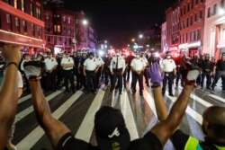 Protesters take a knee on Flatbush Avenue in front of New York City police officers during a solidarity rally for George Floyd, June 4, 2020, in the Brooklyn borough of New York.