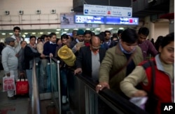 FILE - Indians wait to enter a subway station as they use public transport during a two-week experiment to reduce the number of cars to fight pollution in New Delhi, India, Jan. 4, 2016.