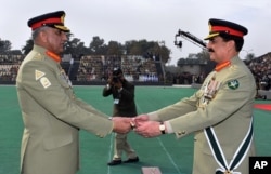 FILE - In this photo released by Inter Services Public Relations, the public relations arm of Pakistan's army, Pakistan's outgoing Army Chief Gen. Raheel Sharif, right, hands over a ceremonial baton to his successor Gen. Qamar Javed Bajwa during the Change of Command ceremony in Rawalpindi, Pakistan, Nov. 29, 2016.
